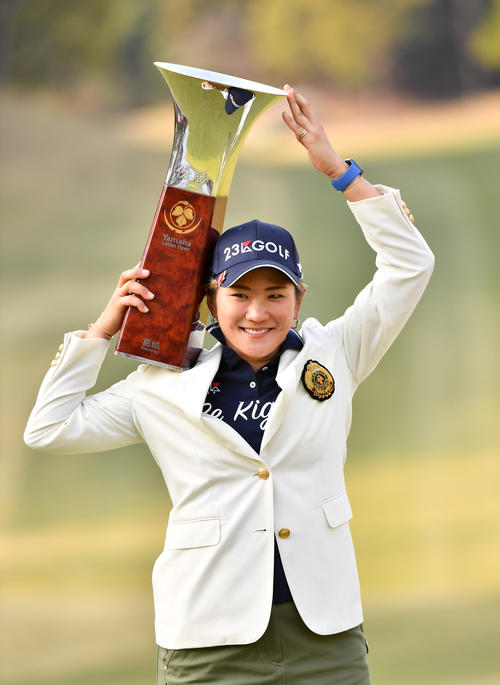 笑顔で優勝杯を掲げる成田（撮影・柴田隆二）