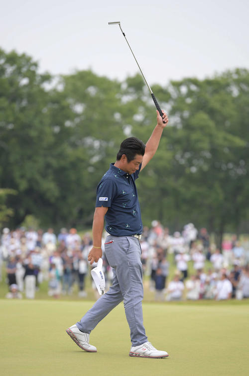 18番、パーパットを沈めて優勝を決め、パターを高く掲げる池田勇太（撮影・加藤諒）