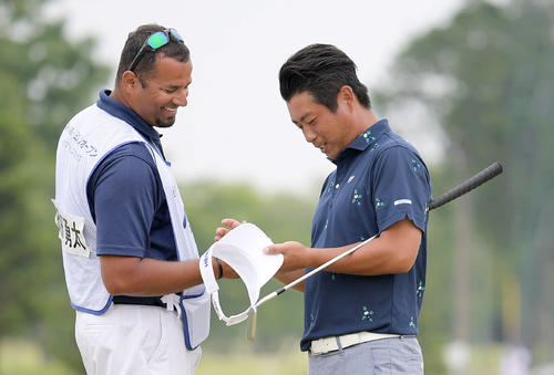 18番、パーパットを沈めて優勝を決め、パターを脇に抱えてキャディーと談笑する池田勇太（撮影・加藤諒）
