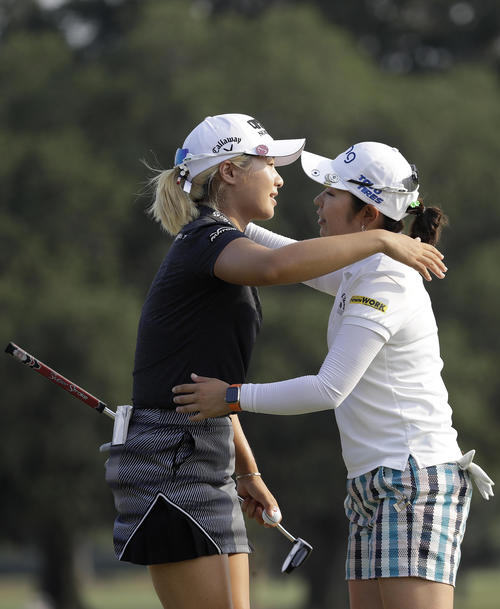 ホールアウト後、比嘉真美子（右）は優勝した李晶恩と健闘をたたえ合う（AP）