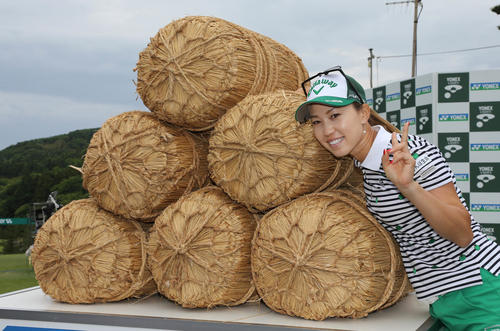 副賞の米俵と写真に納まる上田桃子（撮影・丹羽敏通）