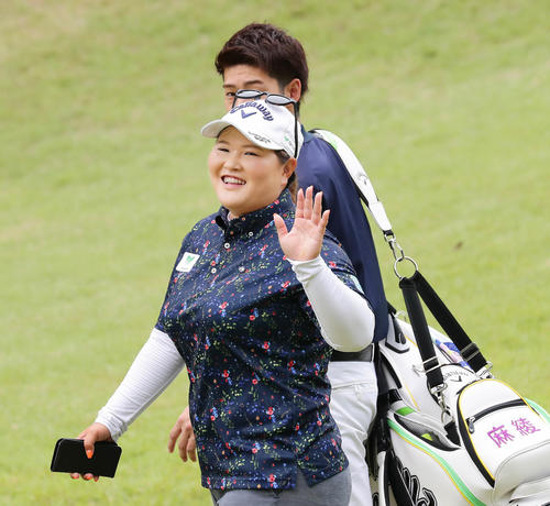 カメラマンに手を振って打撃練習場へ向かう鈴木麻綾（撮影・丹羽敏通）