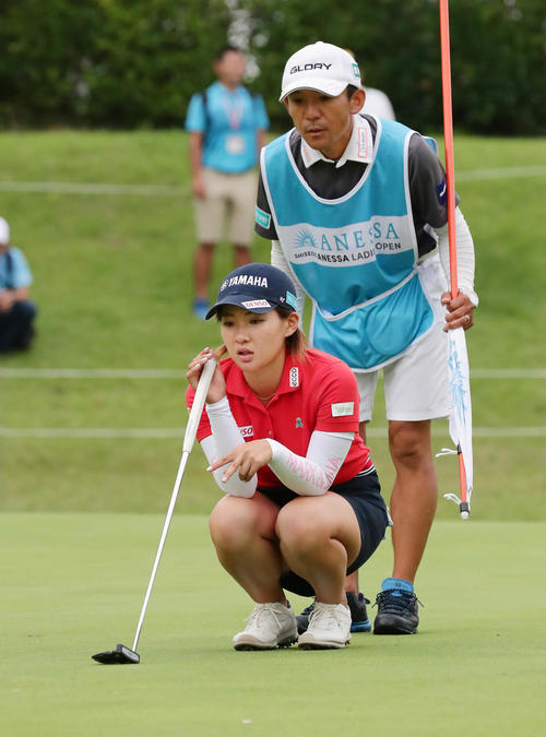 9番、バーディーパットのラインをキャディーと読む永井花奈（撮影・丹羽敏通）