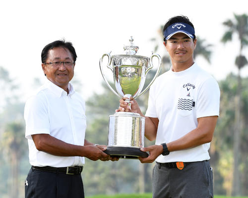 プレーオフで優勝を決め優勝杯を倉本昌弘PGA会長と持ち笑顔の石川遼（撮影・今浪浩三）