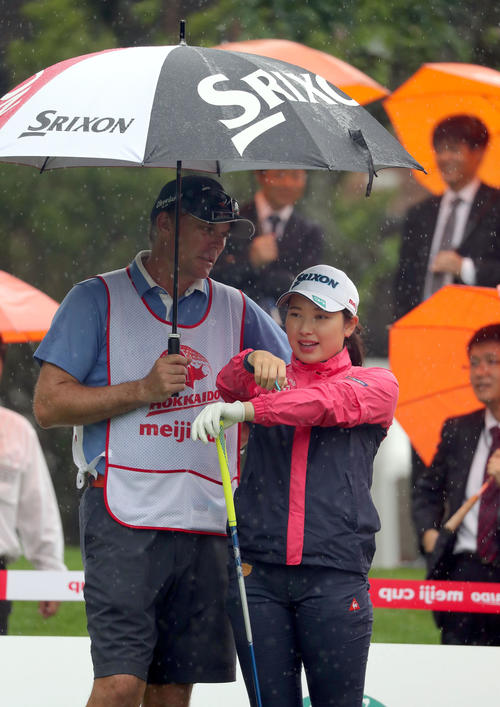 突然の雨に傘の中に入る小祝（撮影・佐藤翔太）