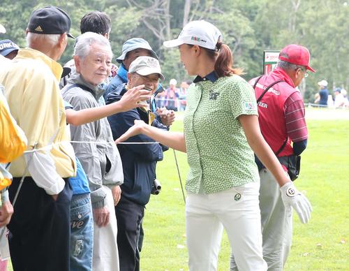 北海道meijiカップ　第2日目　13番を終え子どもの差し出した手に気づかず通り過ぎるも、戻ってタッチする渋野（撮影・黒川智章）