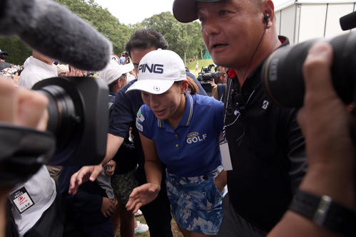 ホールアウト後、多くの報道陣やギャラリーに囲まれながらグリーンを後にする渋野（撮影・佐藤翔太）