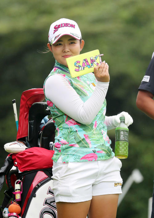 17番、ティーショットを放つ前、カメラマンにスコアカードを見せおどける浅井（撮影・鈴木正人）