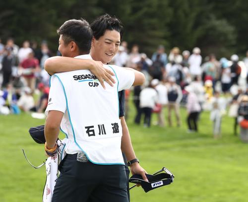 ホールアウト後、キャディー（手前）と抱き合う石川（撮影・黒川智章）