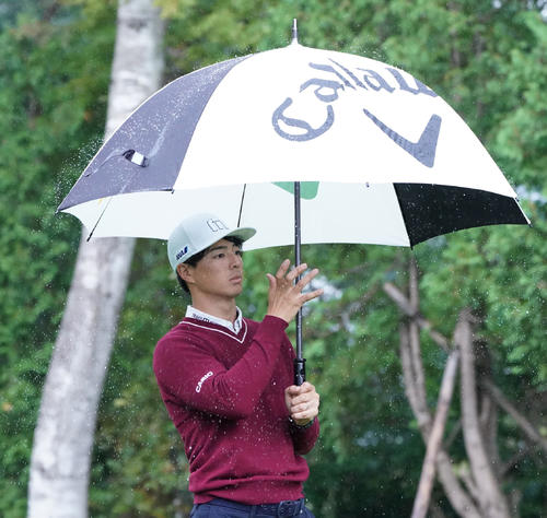 8番、ティーショットを前に、傘についた雨粒を払う石川（撮影・加藤諒）