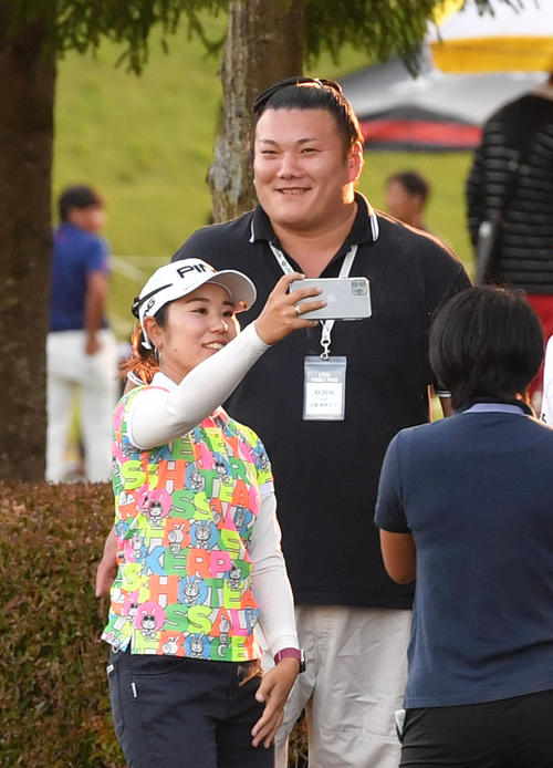 4アンダーで2位の比嘉真美子は応援に来た婚約者の勢と記念撮影する（撮影・柴田隆二）
