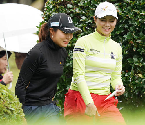2番ティーショットを終えた新垣比菜（右）は高橋彩華と談笑しながらフェアウエーに向かう（撮影・奥田泰也）