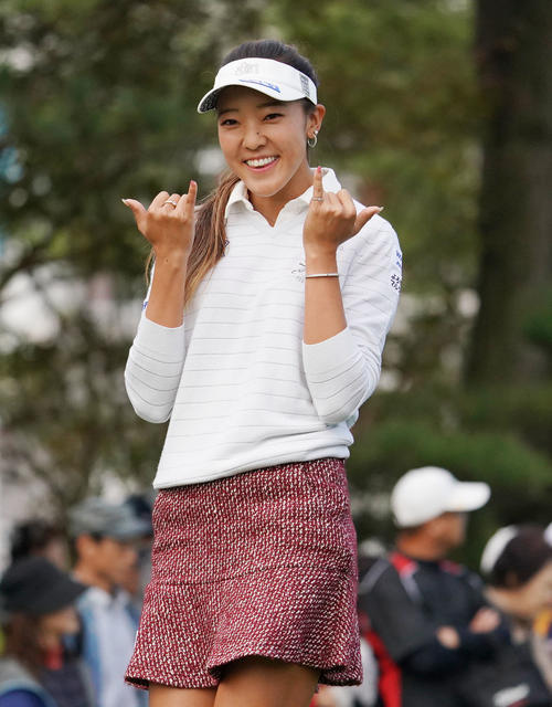 1番ティーショットを終えカメラに向かって笑顔を見せるエイミー・コガ（撮影・奥田泰也）