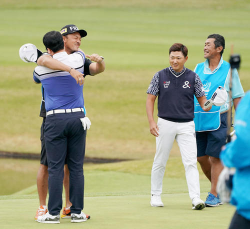18番、優勝を決めるイーグルパットを沈め、キャディーと抱き合って喜ぶ黄重坤（左手前）。右から2人目は惜しくも敗れた今平（撮影・前田充）