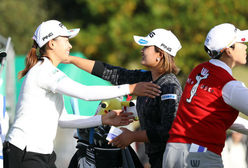 18番、ホールアウトし、鈴木（中央）と抱き合う渋野（左）。右は申（撮影・狩俣裕三）