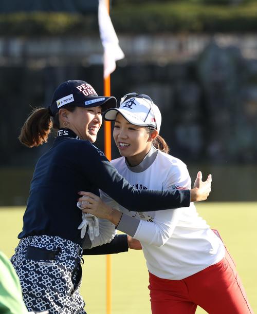 18番、ホールアウトし、同組の木戸愛（左）と抱き合う大江香織（撮影・狩俣裕三）