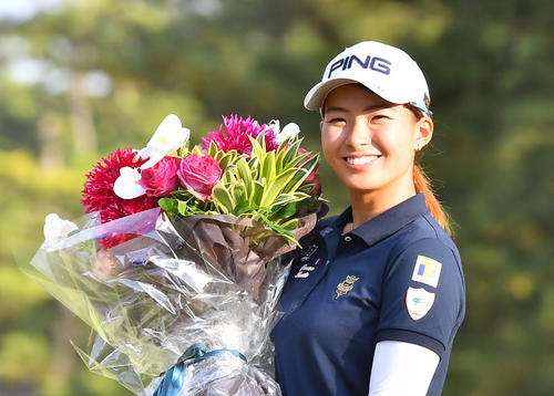 メルセデスランキングで1位となり花束を手に笑顔を見せる渋野（撮影・上田博志）