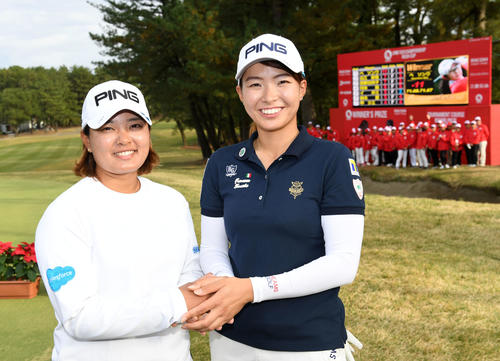 賞金女王となった鈴木（左）と握手を交わす渋野（撮影・横山健太）