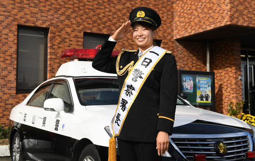 岡山東警察署の一日警察署長を委嘱されたパトカーの前で敬礼する渋野日向子（撮影・前岡正明）