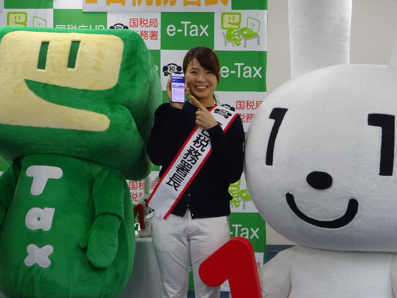 故郷の岡山で一日税務署長を務めた渋野日向子。ゆるキャラのイータ君（左）とマイナ君にはさまれ、笑顔を見せる（撮影・加藤裕一）
