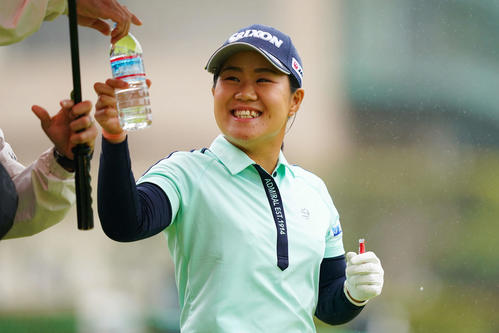 1番、ティーショットを放ち笑顔を見せる畑岡(Getty Images/JLPGA提供)