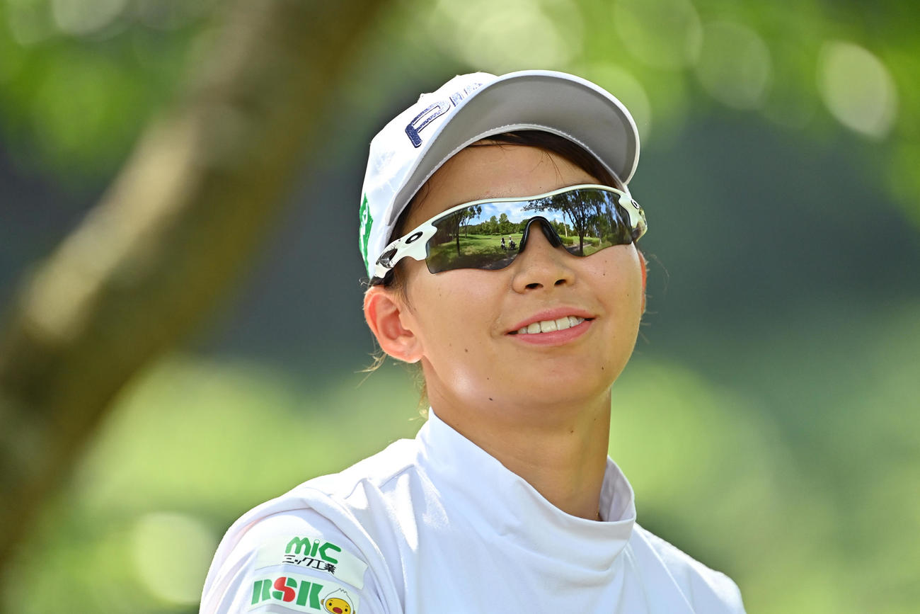 18番ティーグラウンドへ向かう通路でカメラマンに笑顔を見せる渋野（Getty　Images／JLPGA提供）