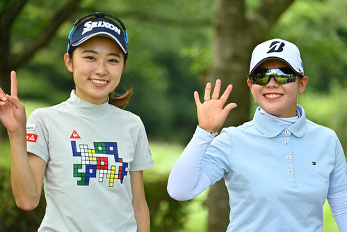 18番のティーグラウンドへ向かう通路でカメラマンにポーズを取る安田祐（左）と吉田優（Getty　Images／JLPGA提供）