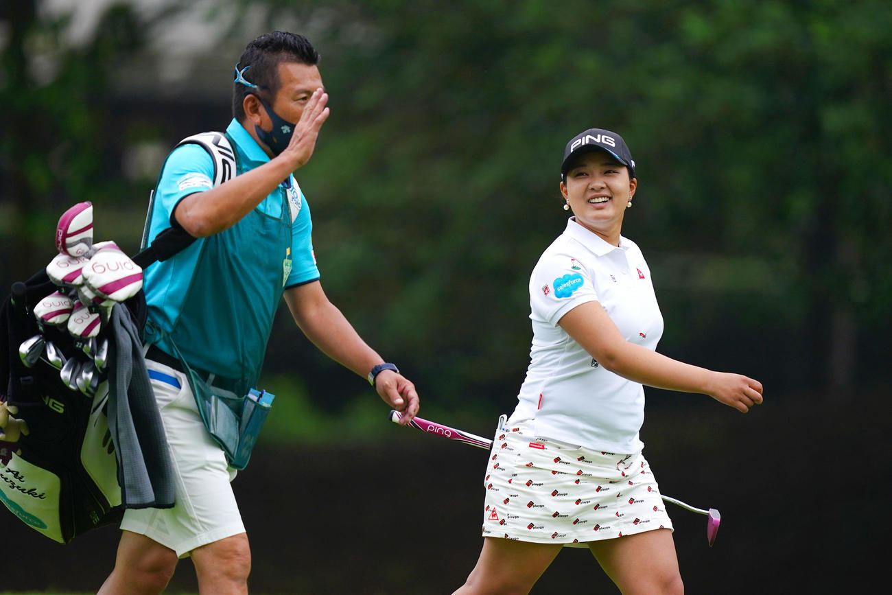 10番、清水キャディー（左）と談笑しながらグリーンへ向かう鈴木（Getty　Images／JLPGA提供）