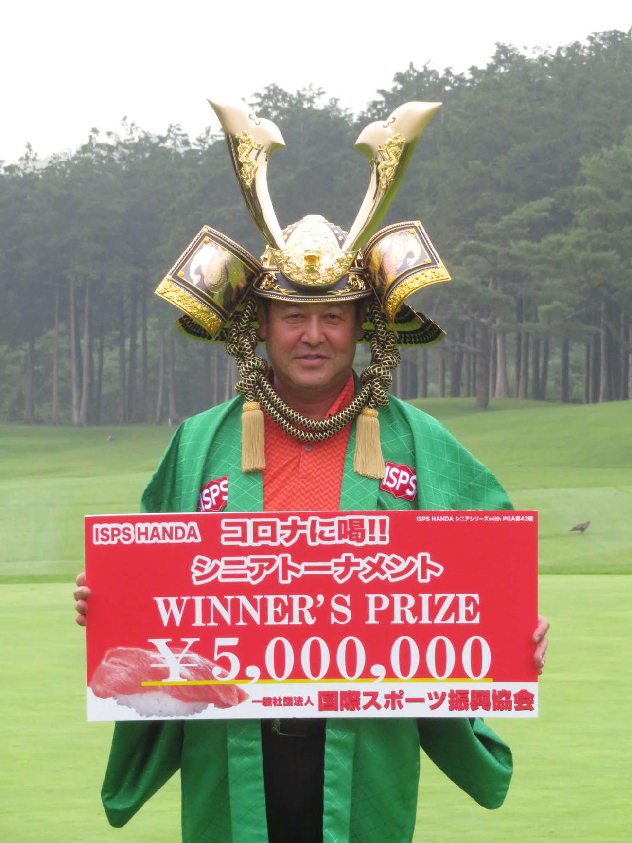 優勝賞金500万円のボードを手に、かぶとを着けて笑顔を見せる柳沢