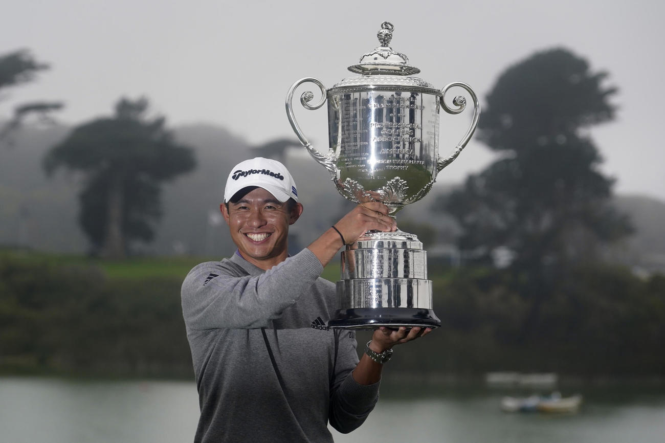 優勝トロフィーを笑顔で掲げるモリカワ（AP）