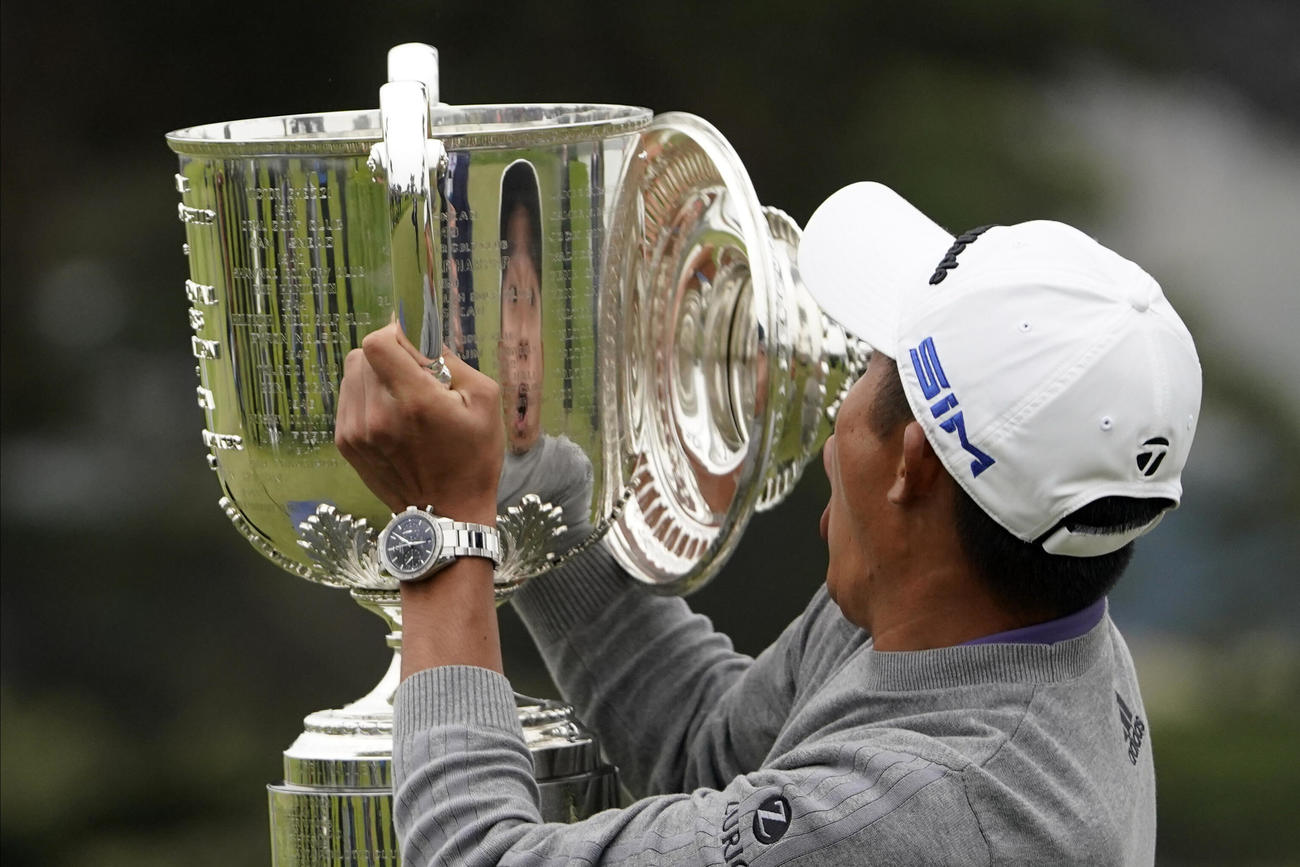 メジャー初優勝を果たしたコリン・モリカワ。フォトセッションで喜びのあまりトロフィーのふたを落としてしまう（AP）