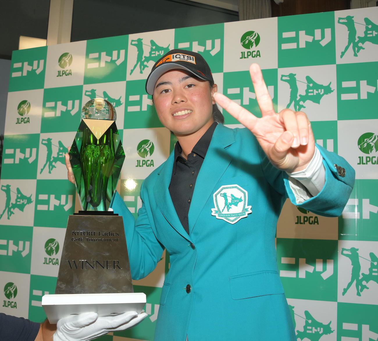2戦連続優勝を決めてトロフィーを手にピースサインする笹生（代表撮影）