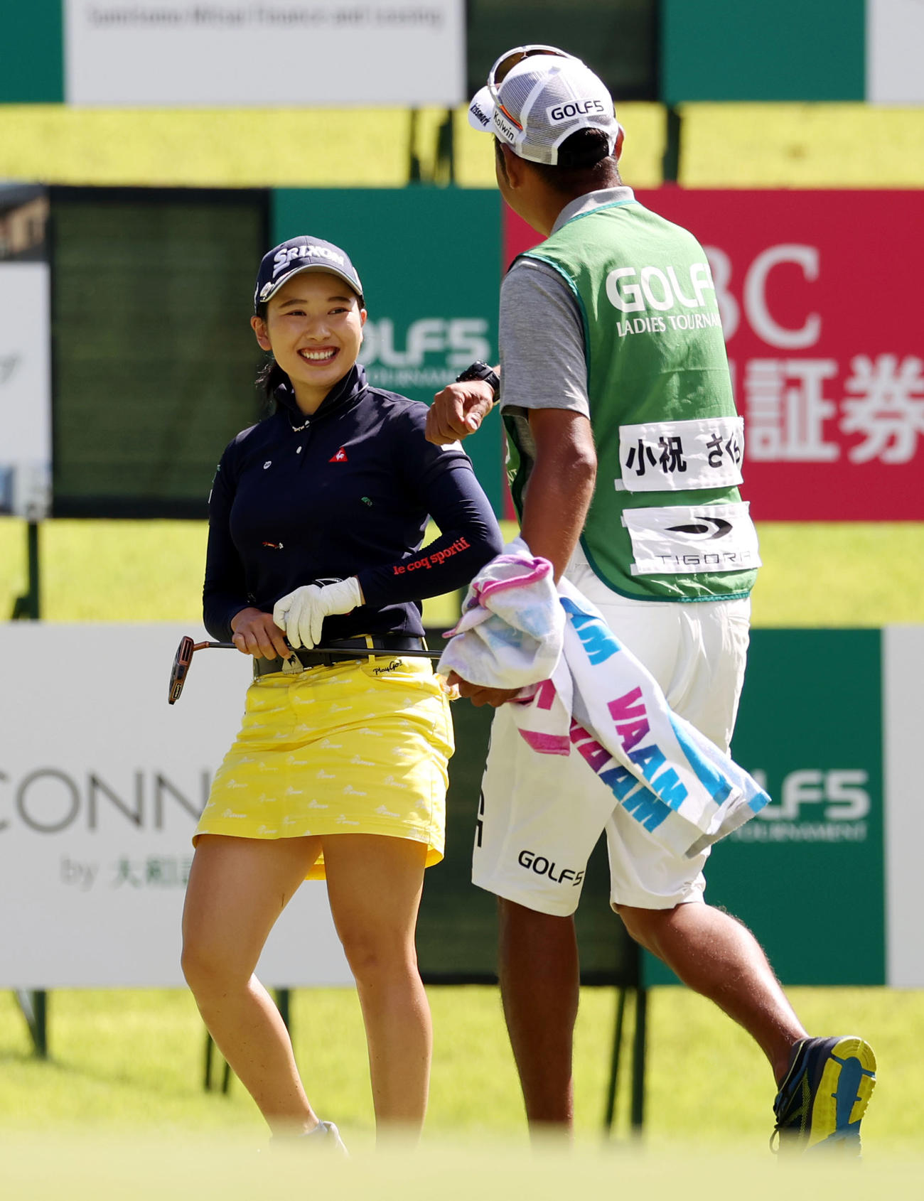 優勝パットを決め、キャディーからヒジタッチで祝福され、笑顔を見せる小祝さくら（撮影・狩俣裕三）
