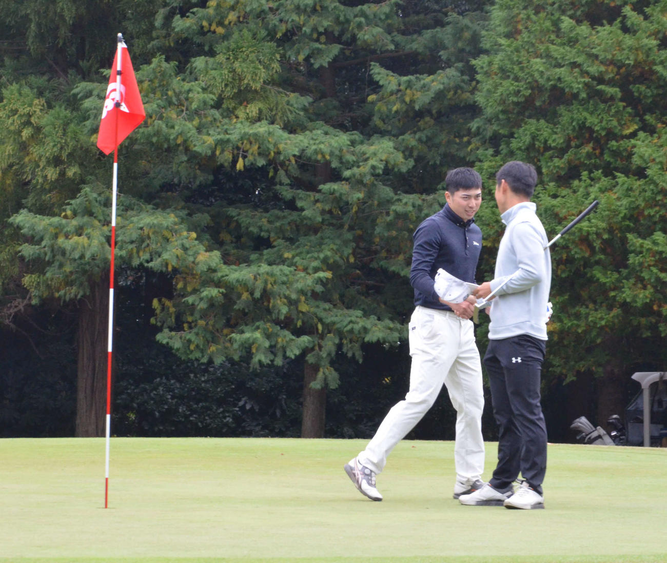 プレーオフの末に勝利し、金田直之と握手を交わす上野晃紀（左）