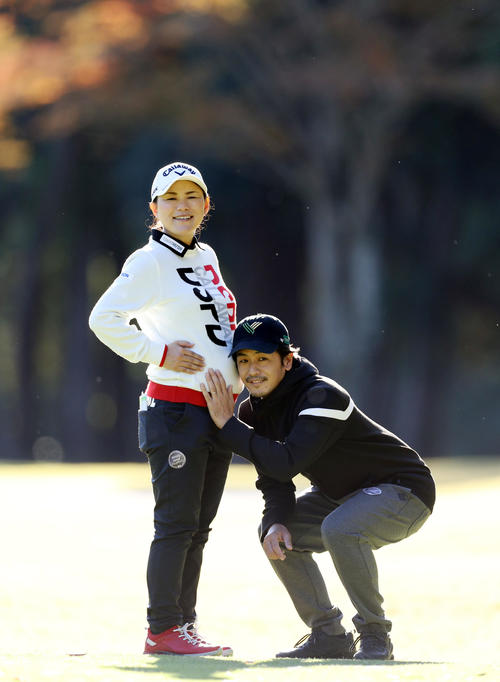 練習ラウンドで、夫の森川キャディー(右)と記念撮影する、妊娠7カ月の横峯(撮影・狩俣裕三)