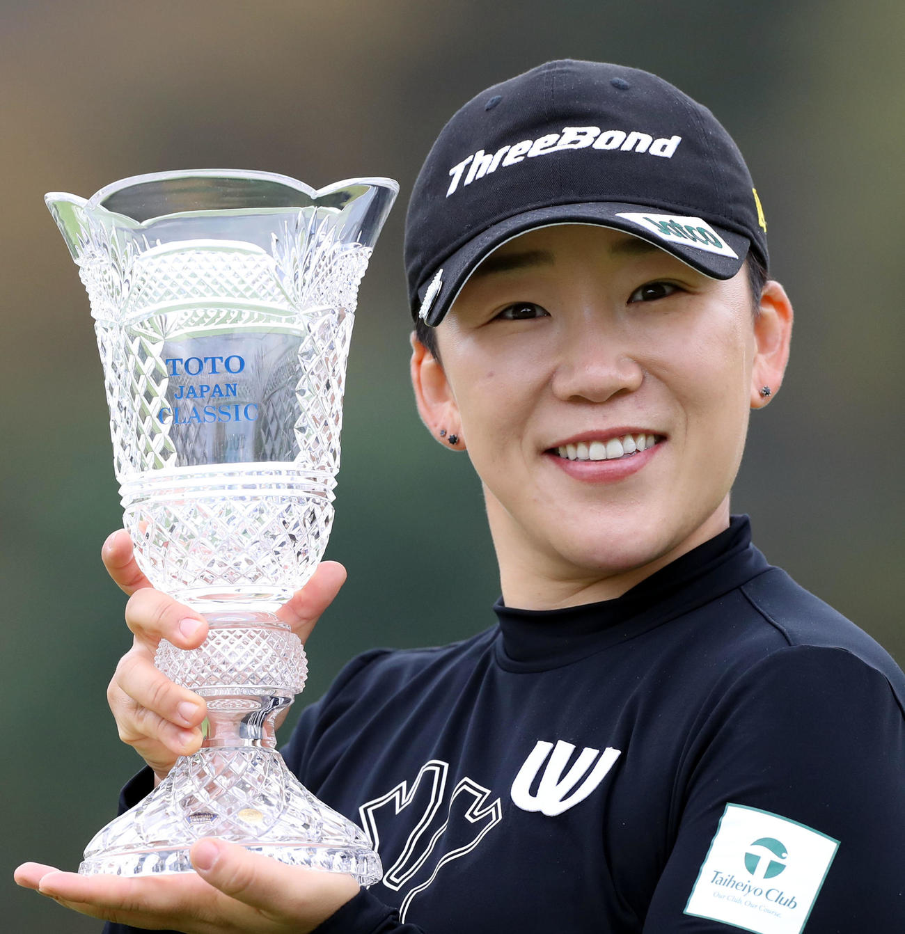 優勝し、カップを手に笑顔を見せる申ジエ（撮影・狩俣裕三）