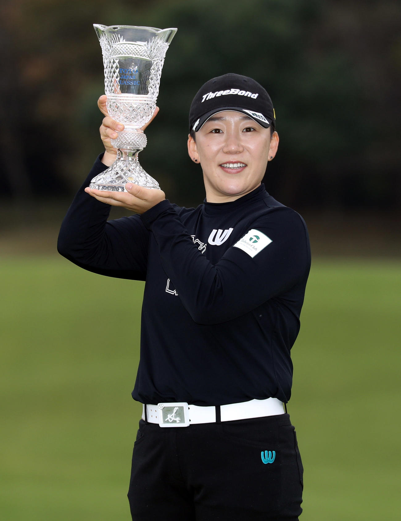 優勝し、カップを手に笑顔を見せる申ジエ（撮影・狩俣裕三）