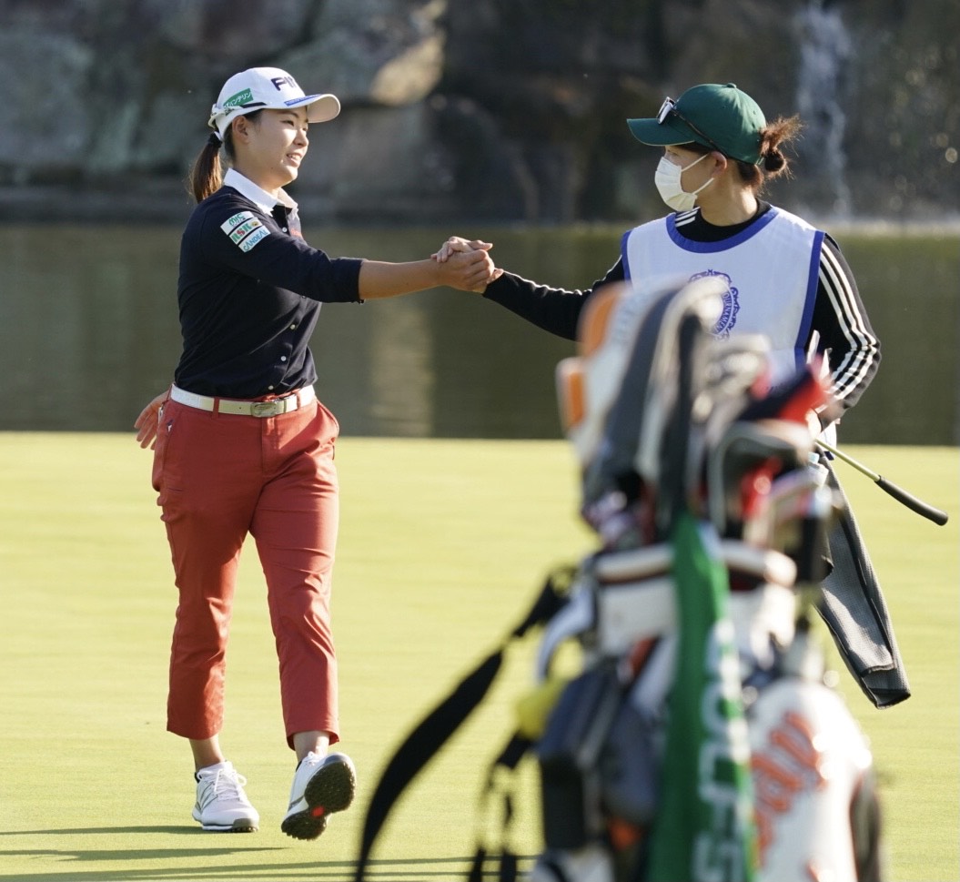 18番、2アンダーでホールアウトし田谷キャディー（右）と握手をかわす渋野日向子（撮影・江口和貴）