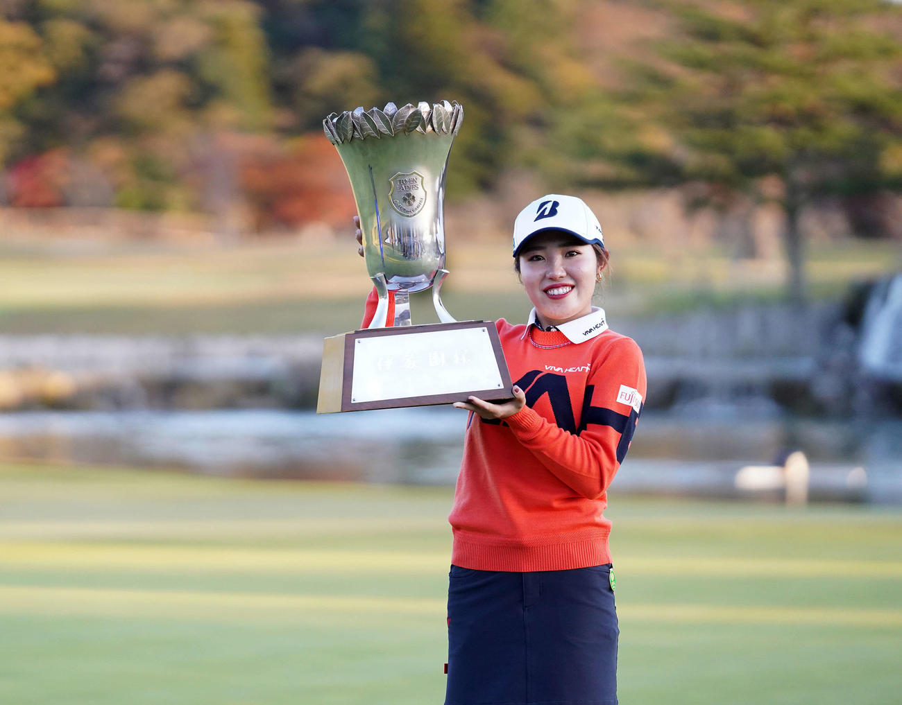 優勝杯を掲げ笑顔を見せる古江彩佳（撮影・江口和貴）