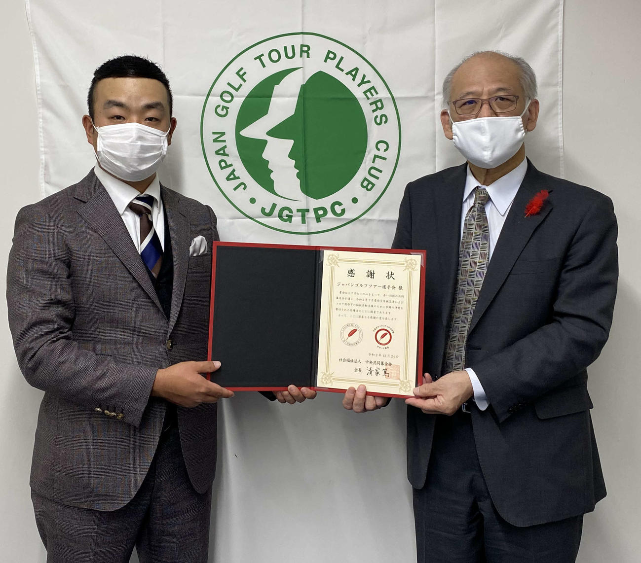 社会福祉法人中央共同募金会の渋谷篤男氏（右）から感謝状を授与されたJGTO選手会長の時松隆光（提供写真）