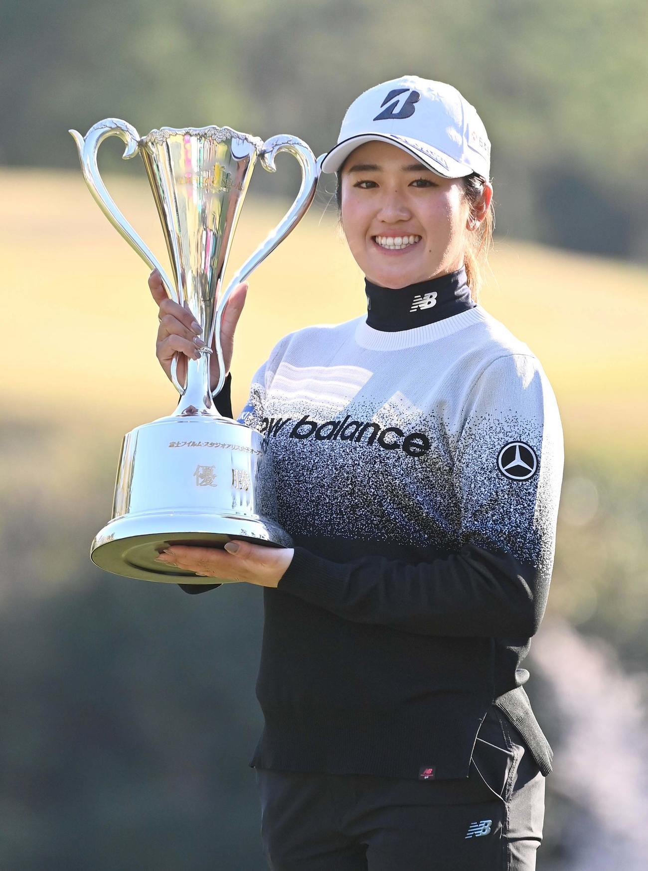 優勝カップを手に笑顔を見せる稲見（撮影・上田博志）