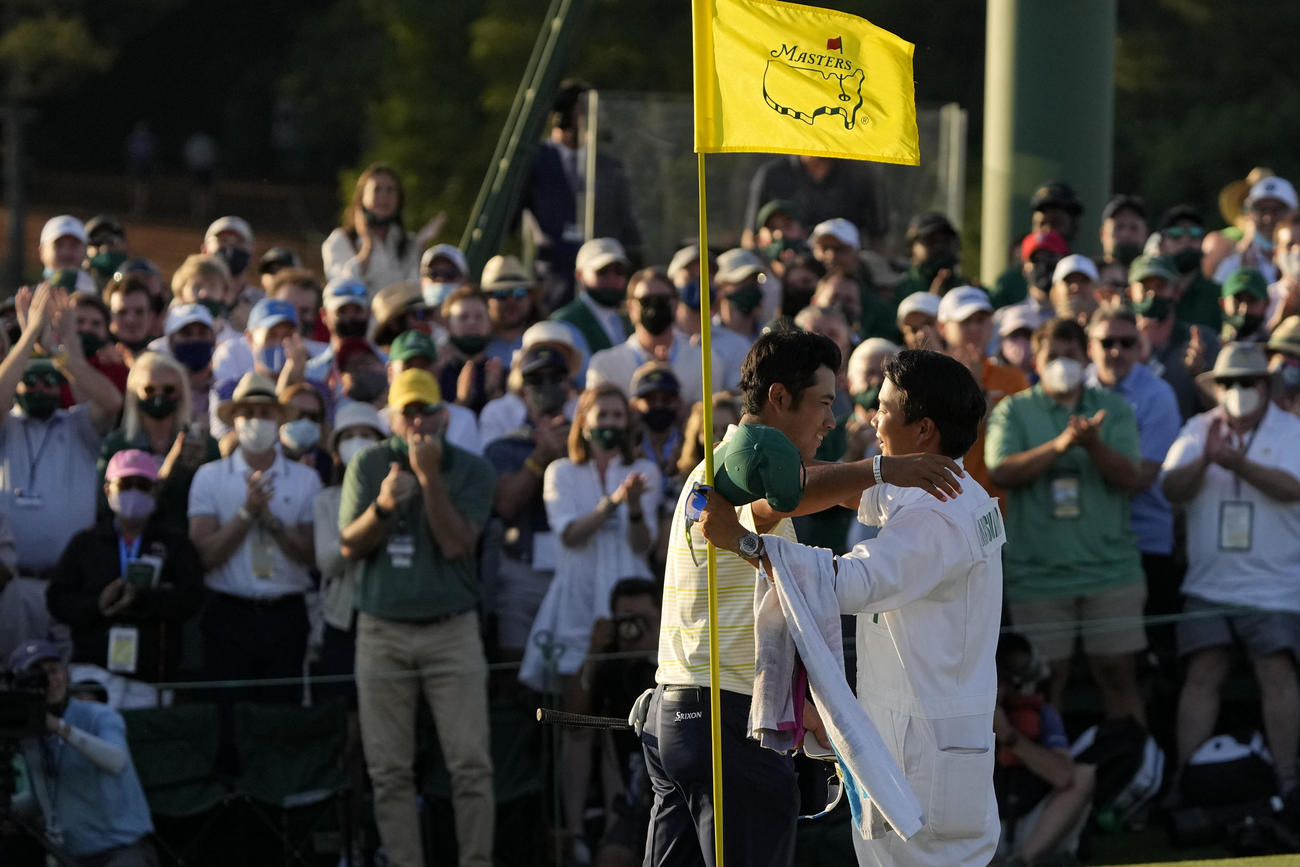 米ゴルフのマスターズ・トーナメントで、日本男子初のメジャー制覇を果たし、キャディー（手前右）と抱き合う松山英樹（AP）