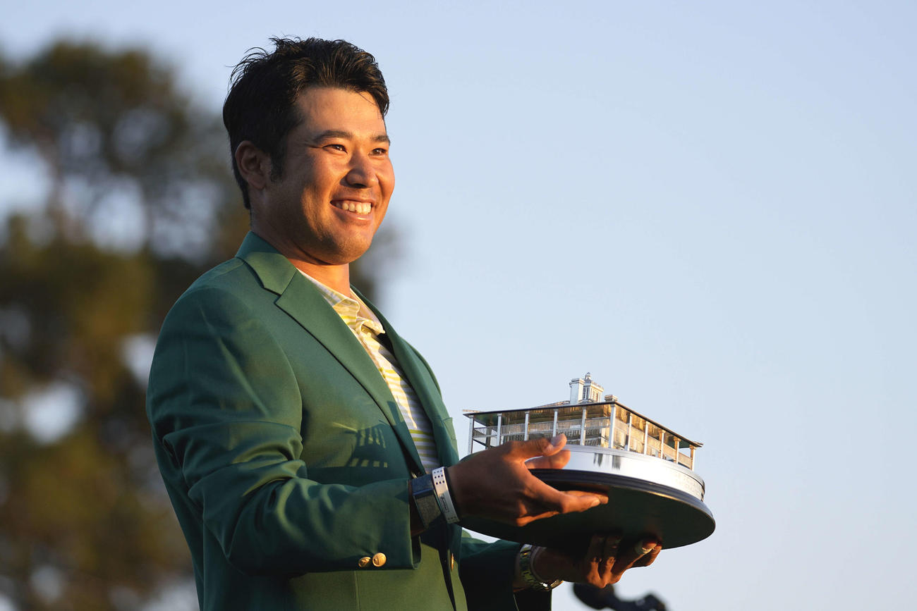 米ゴルフのマスターズ・トーナメントで、日本男子初のメジャー制覇を果たし、トロフィーを手に笑顔の松山（AP）