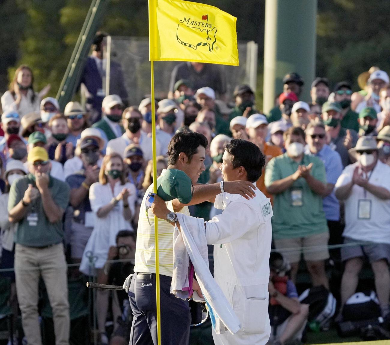 米ゴルフのマスターズ・トーナメントで、日本男子初のメジャー制覇を果たし、キャディー（手前右）と抱き合う松山英樹（AP＝共同）