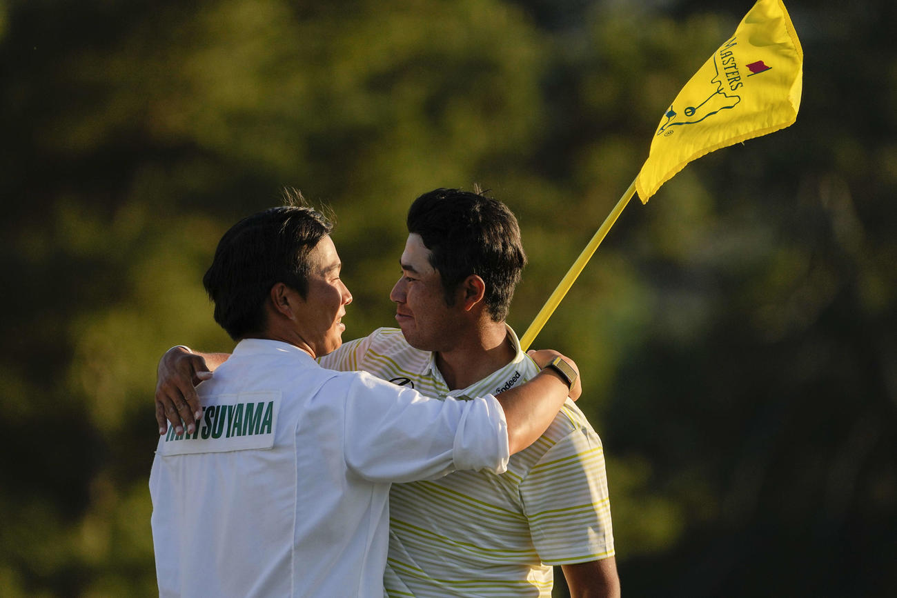 マスターズを制した松山（右）は早藤キャディーと抱き合って喜ぶ（AP）