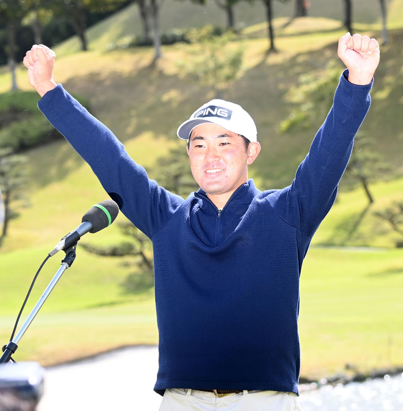通算11アンダーで優勝した金谷はテレビインタビュー後バンザイ（撮影・前岡正明）