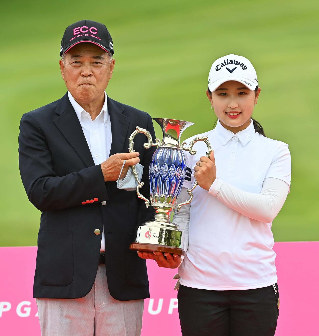 優勝カップを手に笑顔を見せるリ・ハナ（右）と山口勝美大会会長（撮影・上田博志）