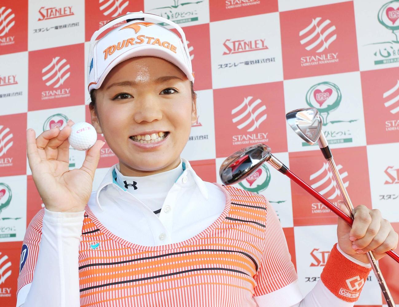 ホールインワンとアルバトロスを達成したクラブと球を持ち、笑顔を振り巻く有村（2011年7月15日撮影）