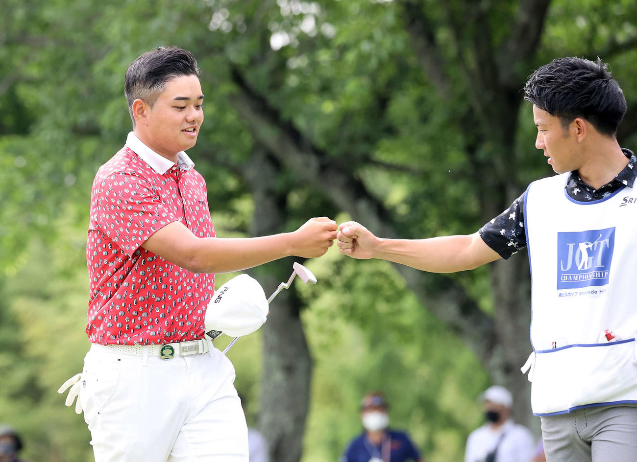 18番を終えキャディー（右）とグータッチする大岩龍一（撮影・鈴木正人）