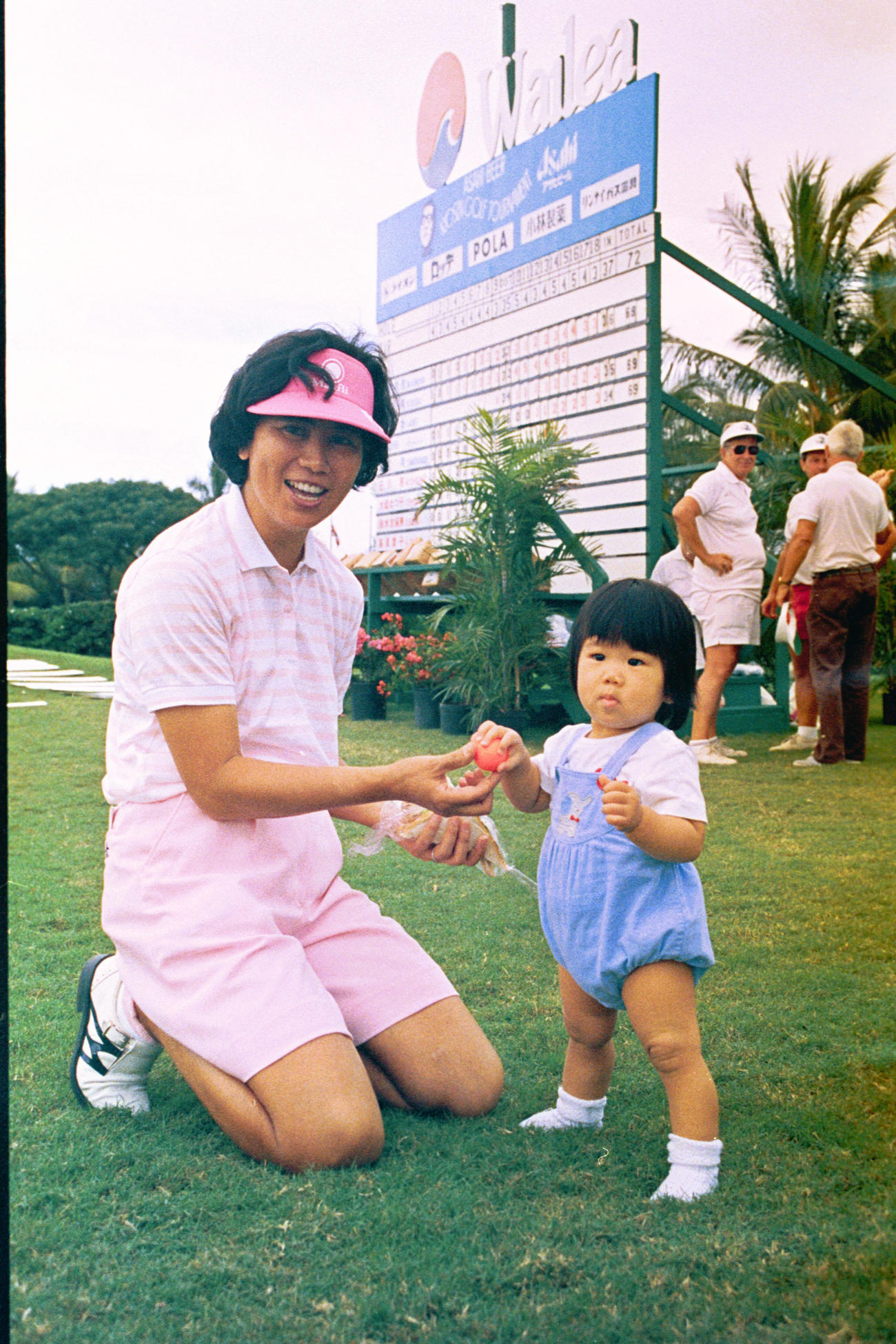 88年に生まれた長女と芝生の上でポーズ